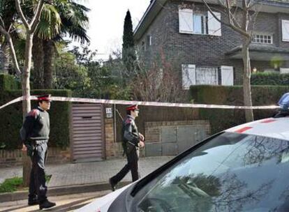 Un policía vigila desde el exterior la casa de la familia Alsina.