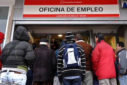 Varios jóvenes esperan delante de una oficina de empleo.