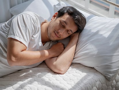 Un hombre durmiendo en un colchón.