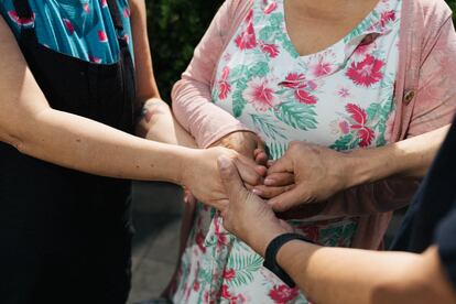 Emily Reid and Sean Ours hold the hands of their mother, Sara Malgarejo.