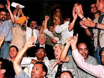 Mosén Josep Maria Vidal, ayer, rodeado de inmigrantes en la iglesia del Pi.