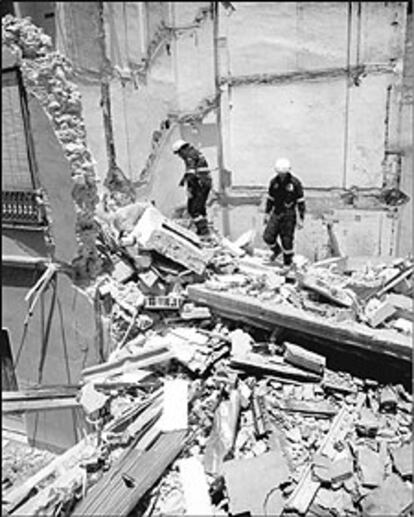 Dos bomberos trabajaban ayer entre los escombros del edificio derruido en Alzira.