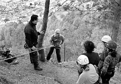 Un monitor da instrucciones a un joven que inicia el descenso en <b></b><i>rappel</i>, ayer, en Cazorla.