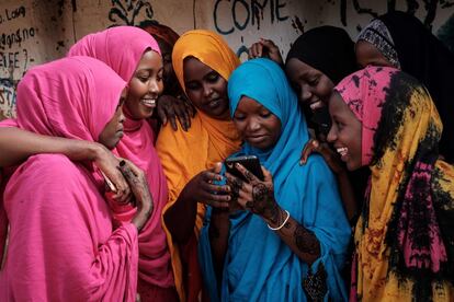 Un grupo de jóvenes refugiadas somalíes miran un teléfono móvil en el campo de refugiados de Dadaab, en el norte de Kenia.