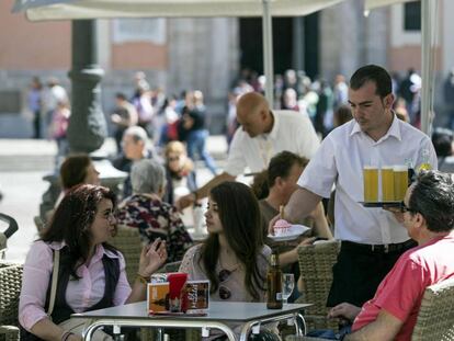 Un camarero sirve bebidas, en una terraza de Valencia.