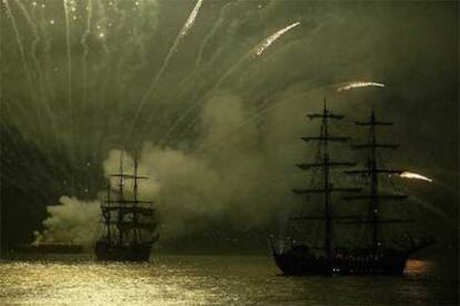 Barcos que navegaron durante el espectáculo <i>Sonne et Lumiere</i> (Luz y Sonido) son iluminados por fuegos artificiales en el puerto de Portsmouth.