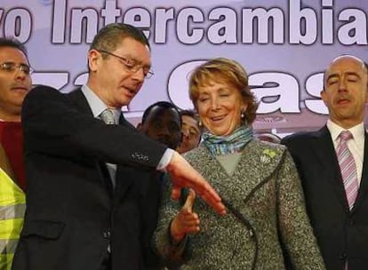 Alberto Ruiz-Gallardón conversa con Esperanza Aguirre ante la mirada del consejero de Transportes, Manuel Lamela, en la inauguración del intercambiador de plaza de Castilla.