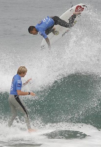 Un surfista vuela sobre la ola en presencia de otro.