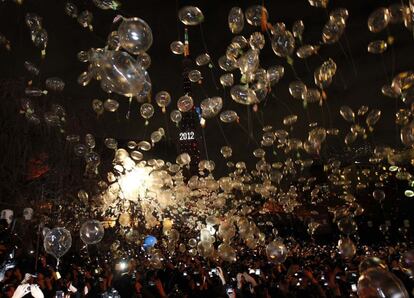 Cientos de japoneses sueltan globos en Tokio durante las doce campanadas que dan paso al nuevo año.