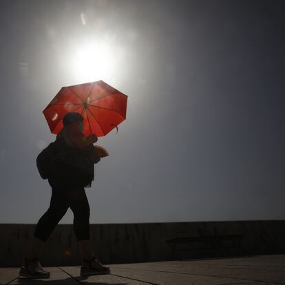 -FOTODELDÍA- COR02. CÓRDOBA, 12/08/2021.- Una mujer camina resguardándose del sol con una sombrilla, hoy en Córdoba, una de las cuatro provincias andaluzas junto a Sevilla, Jaén y Granada que se encuentran en aviso naranja por temperaturas que superan los 40 grados entre las 14.00 y las 21.00 horas, según el pronóstico de la Agencia Estatal de Meteorología (Aemet).EFE/Salas