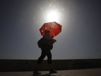 A woman shades herself from the sun in Córdoba in Andalusia.