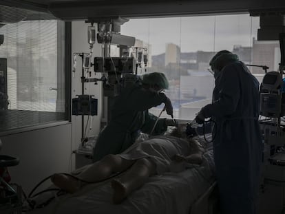 Dos sanitarios atienden a un paciente de covid, en la UCI del Hospital de Bellvitge, en Barcelona.