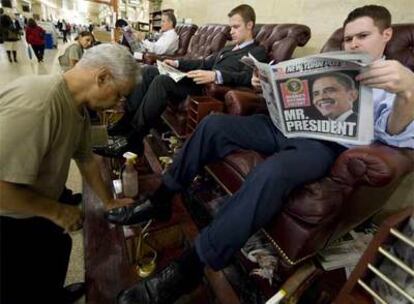 Un hombre lee un periódico con los resultados electorales en la estación central de Nueva York.