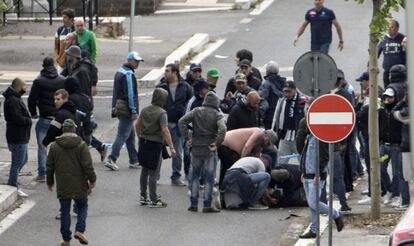 Varios aficionados atienden a un seguidor del Nápoles herido por un disparo. 