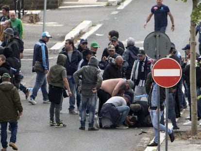 Varios aficionados atienden a un seguidor del Nápoles herido por un disparo. 