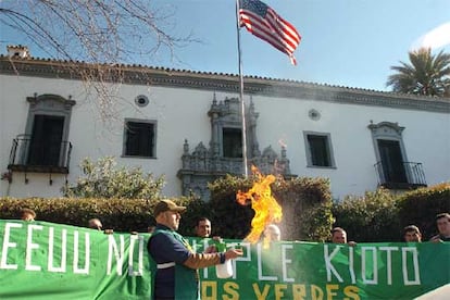 Un manifestante quema gasolina ante el consulado de Estados Unidos en Sevilla durante el acto de protesta de Los Verdes por el no cumplimiento de este país del Protocolo de Kioto para la reducción de la contaminación, que hoy ha entrado en vigor.