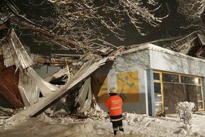 Miembros de los servicios de emergencia, en la puerta del complejo deportivo de Bad Reichenhall, en Baviera, donde se encuentra la pista de hielo cuya cubierta se desplomó la tarde del lunes.