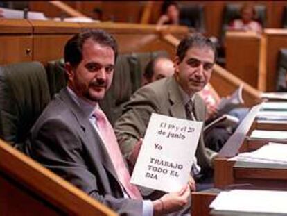 El presidente del PP vasco, Carlos Iturgaiz, muestra un cartel relativo a la huelga en la sede del Parlamento vasco