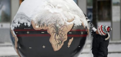 Un niño juega con la nieve y una bola del Mundo en Copenhague