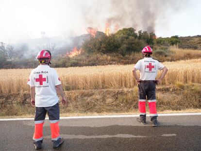 Dos miembros de la Cruz Roja observan la evolución del incendio de Tafalla, en Pamplona (Navarra). El Gobierno de Navarra ruega encarecidamente a la población que extreme las precauciones y evite cualquier práctica o actividad que pueda conllevar riesgo de causar nuevos incendios.