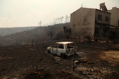 Una vivienda y un coche quemados tras un incendio forestal en Dionysos, al norte de Ática.