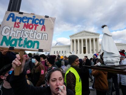 An abortion rights activist, left, protests as people carry a statue of Our Lady of Fatima outside of the U.S. Supreme Court during the March for Life, Friday, Jan. 20, 2023, in Washington.