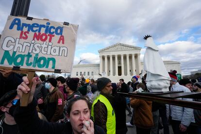 An abortion rights activist, left, protests as people carry a statue of Our Lady of Fatima outside of the U.S. Supreme Court during the March for Life, Friday, Jan. 20, 2023, in Washington. (AP Photo/Alex Brandon)