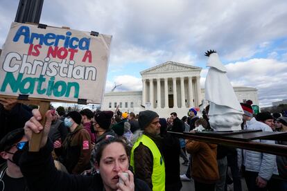 An abortion rights activist, left, protests as people carry a statue of Our Lady of Fatima outside of the U.S. Supreme Court during the March for Life, Friday, Jan. 20, 2023, in Washington.