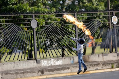 Un manifestante opositor al Gobierno lanza una bomba de gasolina contra las fuerzas de seguridad durante una protesta en Caracas, el 23 de junio de 2017.