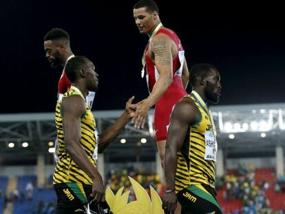 Desde lo alto del podio, Ryan Bailey saluda a Usain Bolt tras el mundial de relevos de Bahamas.