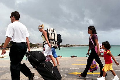 Un grupo de turistas sale apresuradamente del muelle de Playa del Carmen, en el estado mexicano de Quintana Roo, justo cuando empeizan a caer las primeras del ciclón.