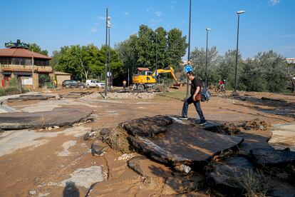 Un peatón atraviesa una zona dañada por la fuerte lluvia en Zaragoza, este viernes. 