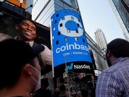 People watch as the logo for Coinbase Global Inc, the biggest U.S. cryptocurrency exchange, is displayed on the Nasdaq MarketSite jumbotron at Times Square in New York, U.S., April 14, 2021.