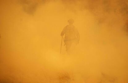 Un bombero se interna en el humo para sofocar el incendio en Lakeport, California.