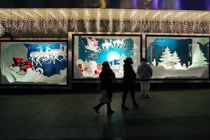 Varias personas pasean anoche por el centro de Madrid, con los escaparates engalanados por Navidad.