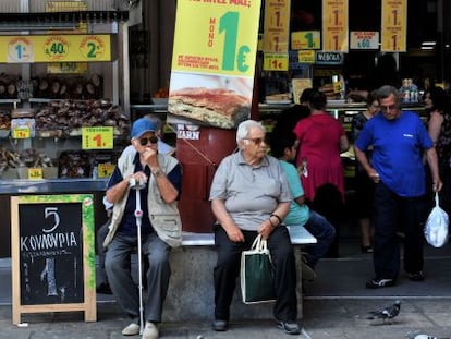 Viandantes junto a una tienda de Salónica.