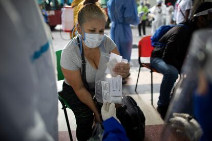 Paciente assintomática recebe da médica uma sacola com cloroquina, azitromicina e dexametasona, em 25 de agosto, em Caracas. 