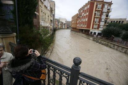 Una mujer fotografía el río Segura a su paso por Orihuela, el 19 de diciembre de 2016.