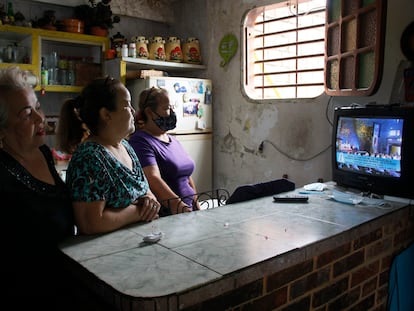 Mujeres venezolanas, observan la televisión en un barrio de Caracas.