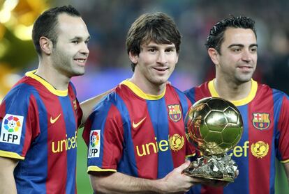 Iniesta e Xavi acompanham Messi, que posa com a bola de ouro, antes de um encontro das quartas de final da Copa do Rei contra o Betis noNou Camp em 2011.