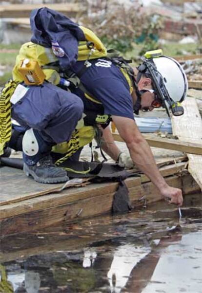 Un técnico toma una muestra de agua estancada para su análisis.