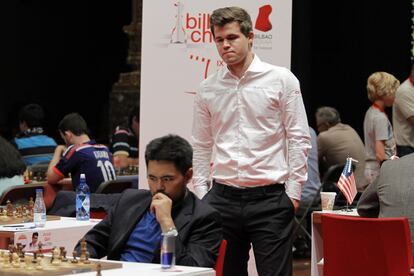 Carlsen, de pie, observa de cerca la partida de Nakamura, ayer en Bilbao
