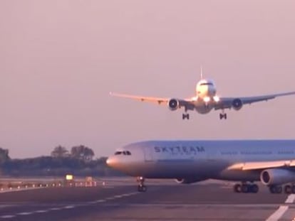 The plane makes its landing approach as another one crosses the runway.