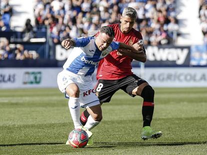 Roque Mesa protege el balón ante Salva Sevilla.