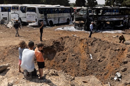 Varias personas observan un cráter en el suelo tras el impacto de un misil lanzado desde Irán, este martes en Herzliya (Israel).