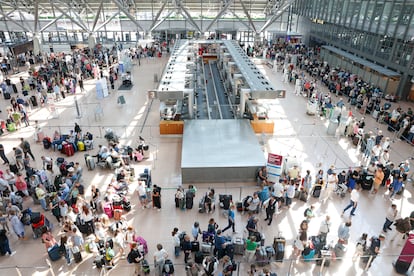 Centenares de personas hacen cola en la zona de facturación del aeropuerto de Hamburgo (Alemania), este viernes. 
