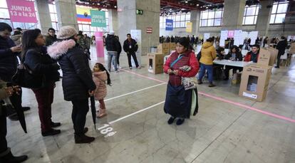 Ciudadanos ecuatorianos hacen cola para votar en el Pabell&oacute;n de Cristal de Madrid, este domingo.