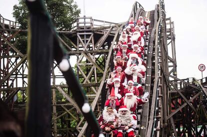 Personas disfrazadas de Santa Claus en una montaña rusa en el parque de atracciones Dyrehavsbakken, al norte de Copenague, durante el Congreso Anual de Santa Claus.