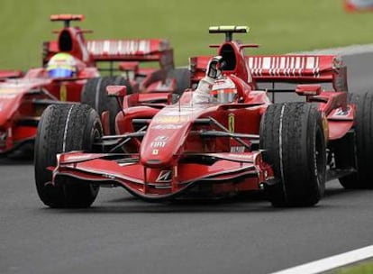 Kimi Raikkonen saluda al público tras su triunfo de ayer en el Gran Premio de Francia. Tras él, su compañero Felipe Massa.