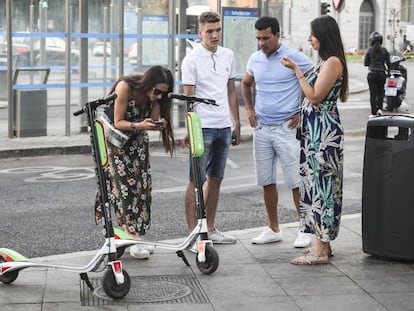 Varias personas observan los nuevos patinetes eléctricos de la empresa de alquiler Lime, en la plaza de Cibeles.